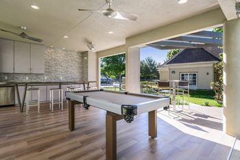 a patio with a pool table and a bar